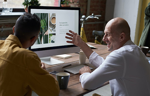 bald guy explaining to a man in front of screen Nurturing a Growth Mindset How to Cultivate a Culture of Continuous Learning body
