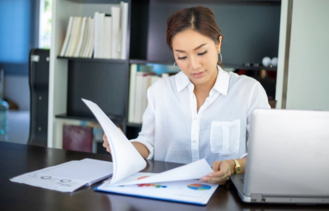woman checking paperwork Work Smarter, Not Harder Strategies for Boosting Productivity body